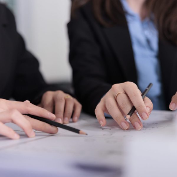 Architects working on cad project, designers hands with pencils on blueprint closeup. Real estate agency employees drawing architectural draft, writing building technical plan concept